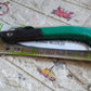 Folding saw for tree trimming and various cutting tasks, ideal for camping and gardening.