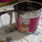 Easy-to-use manual flour sifter with a shaker mechanism, ideal for precise and lump-free baking.